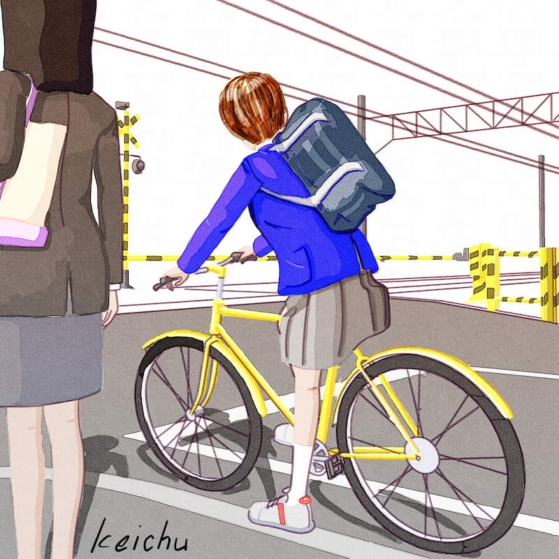 自転車に乗って踏切を待つ女子学生